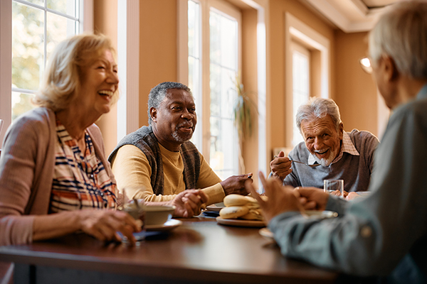 Older Adults eating at table in assisted living facility