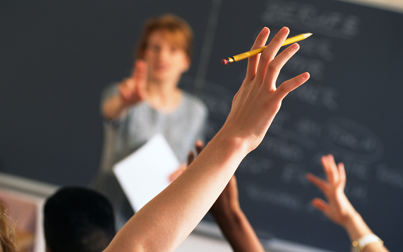 student raising hand in class