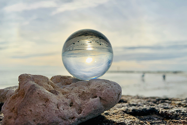 crystal ball sitting on a rock by the water