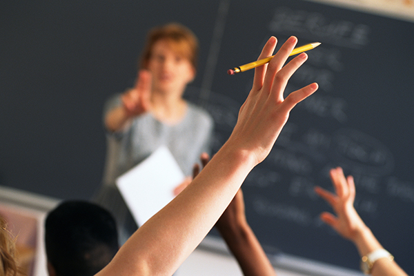 Student raising hand in a classroom