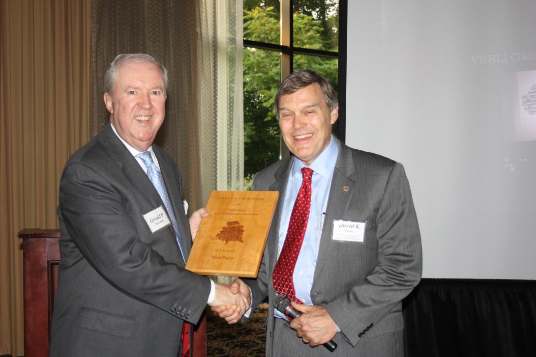 David Paylor receives an award from Gerald McCarthy (two men shaking hands over a plaque).