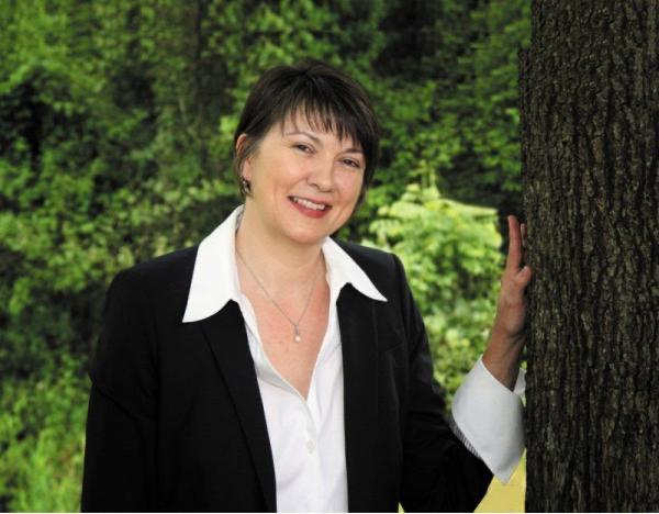 headshot of a woman next to a tree (Bettina Ring)